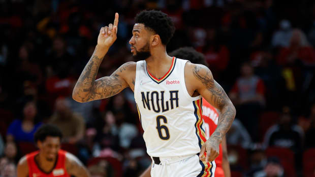 Pelicans guard Nickeil Alexander-Walker points up to the ceiling during a game.